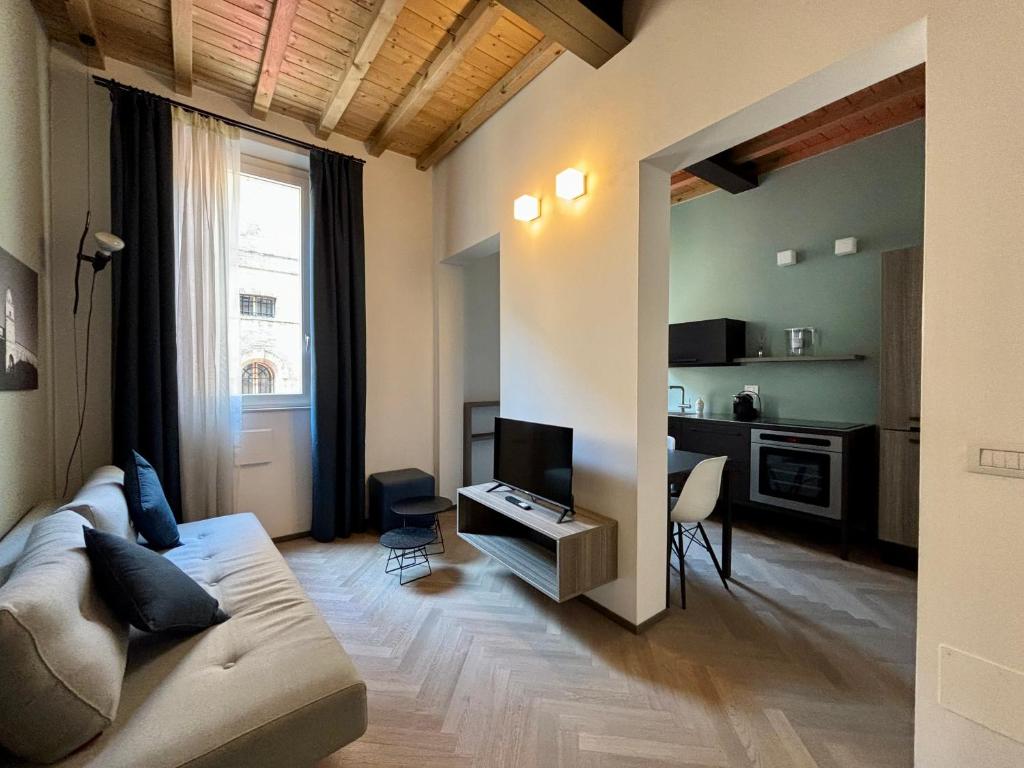 a living room with a couch and a television at Saragozza Suite 2 Intero appartamento in centro storico WIFI e parcheggio gratuito in Modena