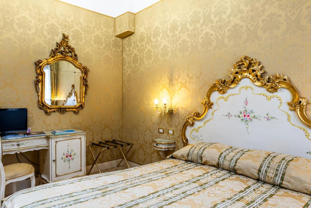 a bedroom with a large bed and a mirror at Hotel Ca' Dogaressa in Venice