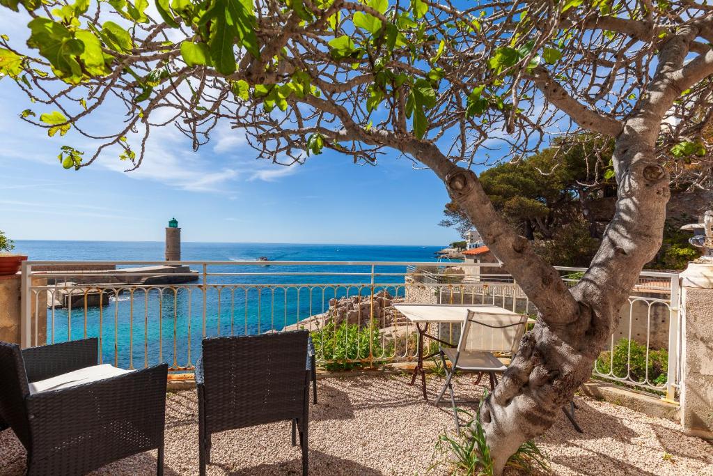 Un patio con mesa y sillas y el mar. en L'aiguade - Cassis, en Cassis