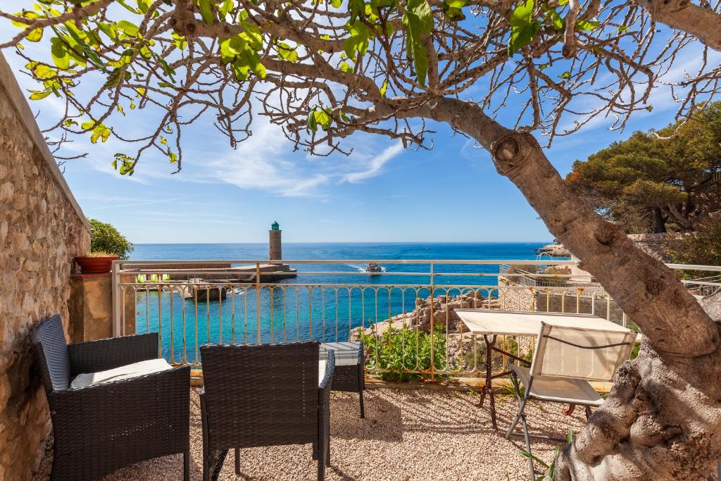 a patio with a table and chairs and the ocean at L'aiguade - Cassis in Cassis