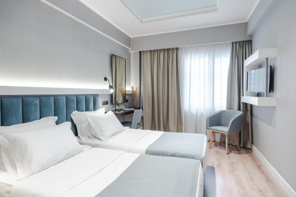 Habitación de hotel con 2 camas y TV en Athens Cypria Hotel, en Atenas