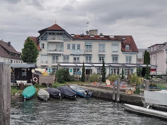 Hotel Seeschau في رايشناو: مبنى ابيض كبير وفيه قوارب في الماء