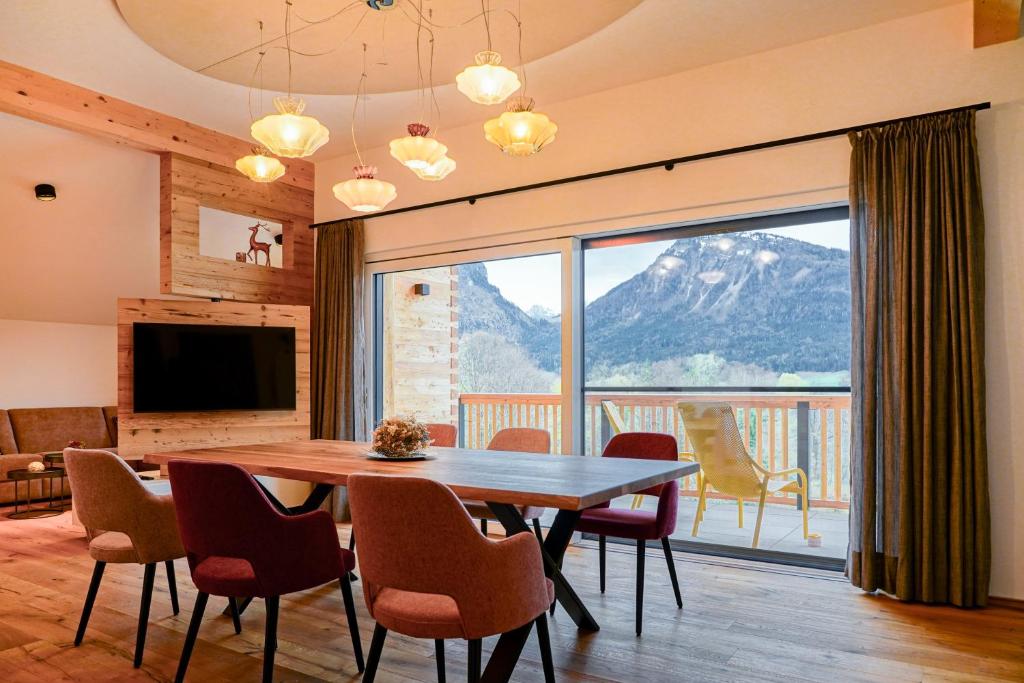 ein Esszimmer mit einem Tisch und einem großen Fenster in der Unterkunft Haus Alpenblick in St. Wolfgang