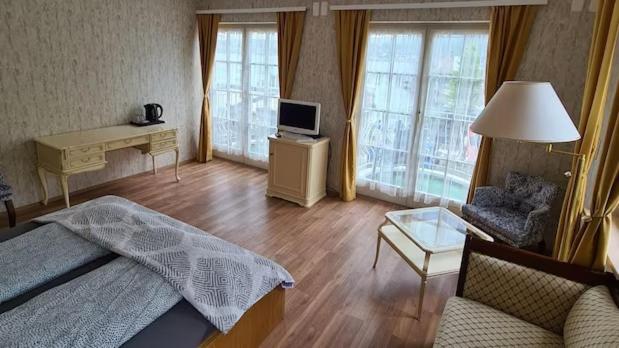 1 dormitorio con cama, escritorio y sofá en Hotel Seeschau, en Reichenau
