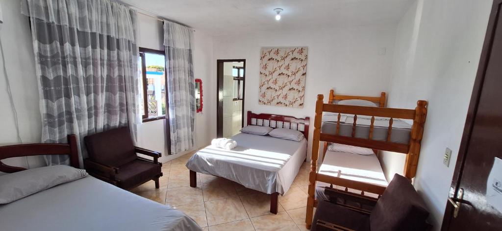 sypialnia z 2 łóżkami piętrowymi i krzesłem w obiekcie Pousada dos Félix w mieście São Gabriel