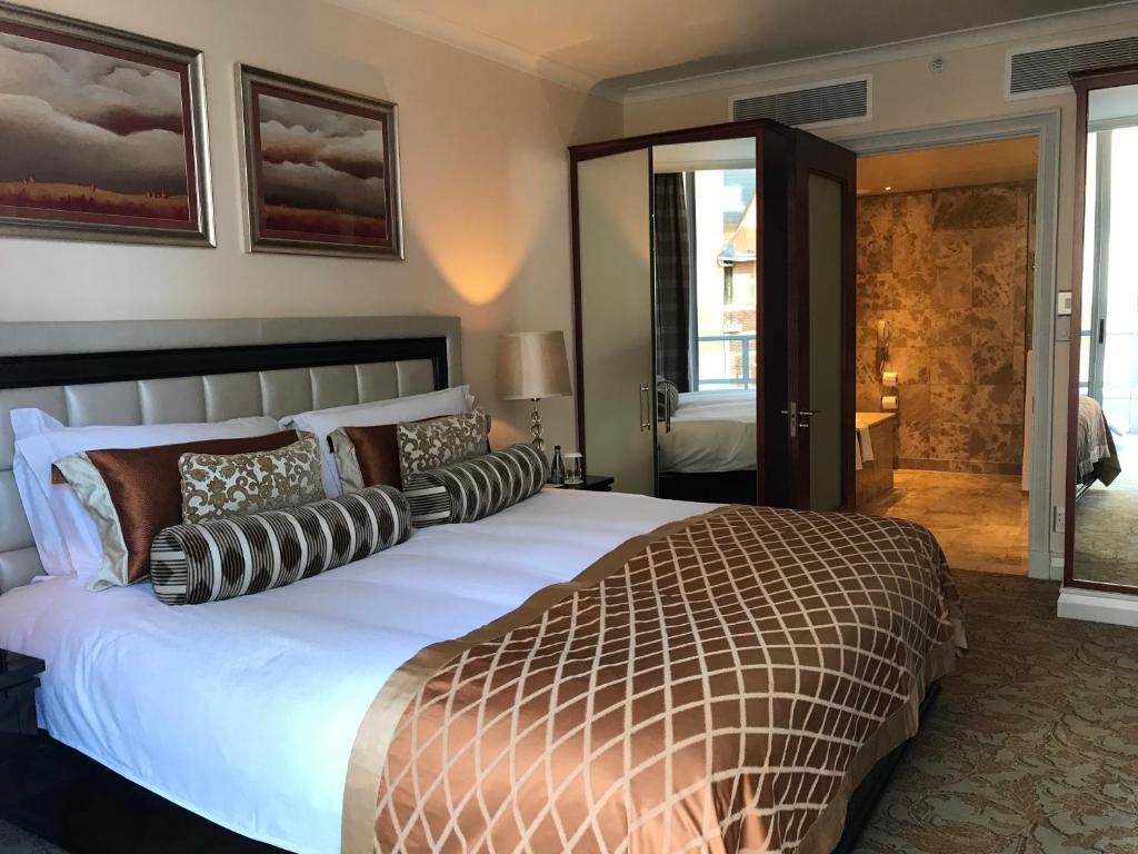 a bedroom with a large bed with pillows at TAJ Cape Town - Private Luxury One Bedroom Suite in Cape Town