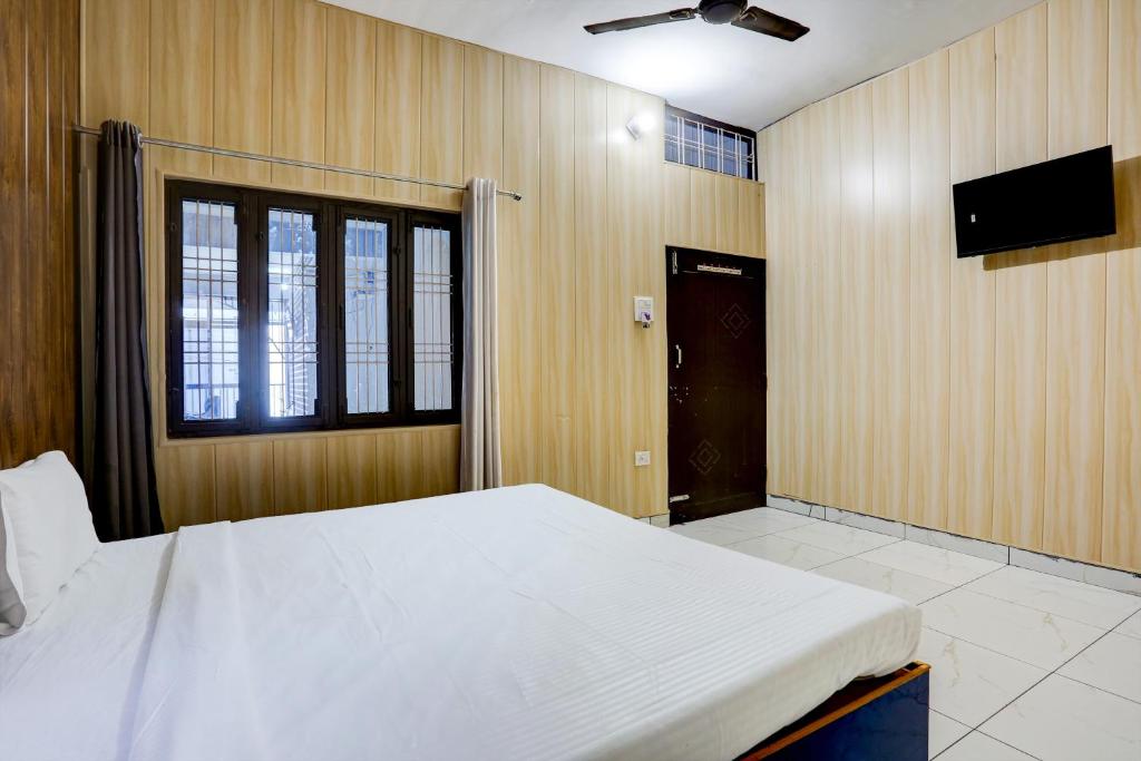 una camera con letto e TV a schermo piatto di OYO Hotel The Selaqui Paradise a Jhājra