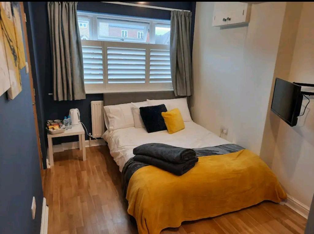 ein kleines Bett in einem Zimmer mit Fenster in der Unterkunft Double Room with ensuite close to silverstone in Whittlebury
