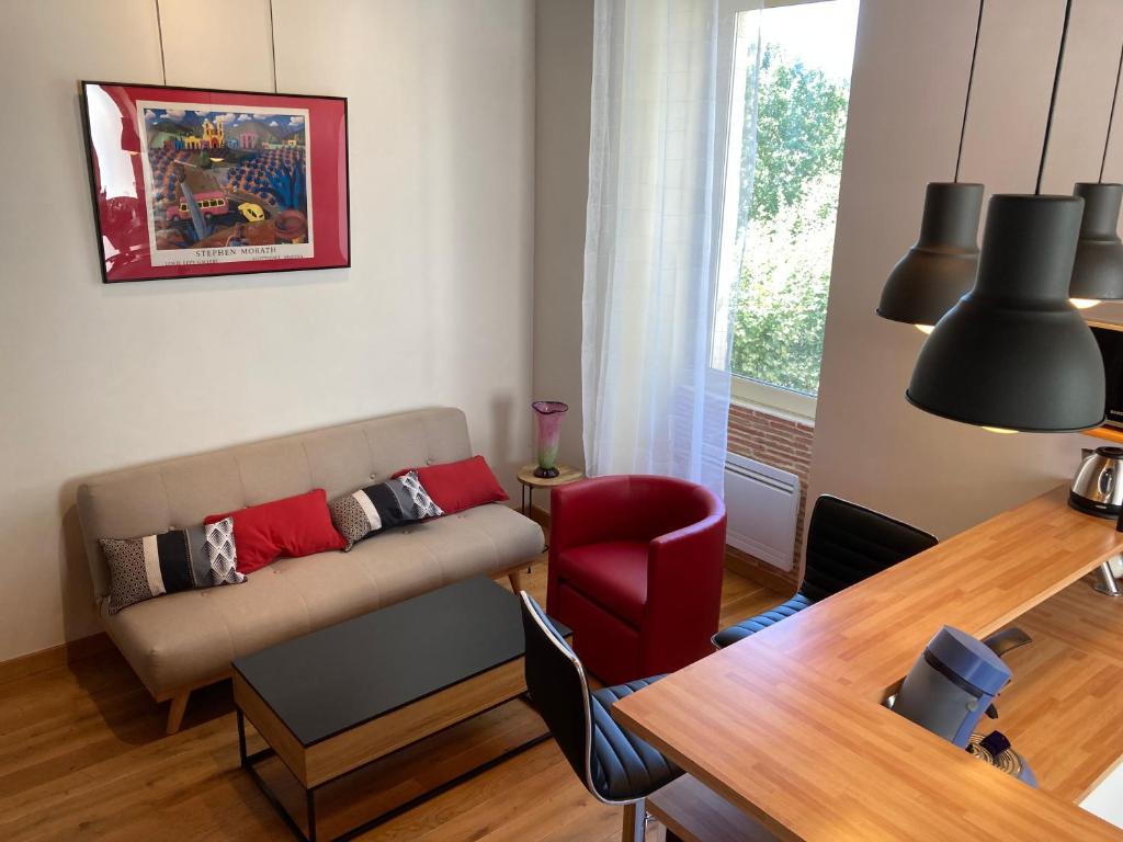 salon z kanapą i stołem w obiekcie charmant appartement centre ville w mieście Millau