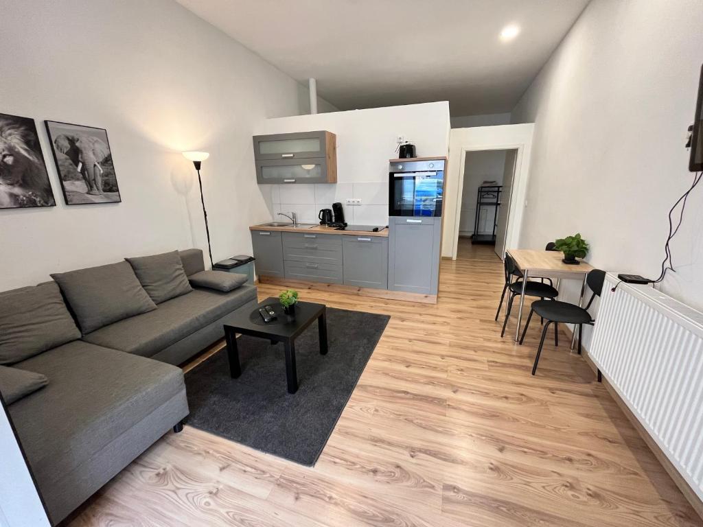 un soggiorno con divano e tavolo di Apartment Central 10B 40qm Wi-Fi free Parking calm back house a Dortmund