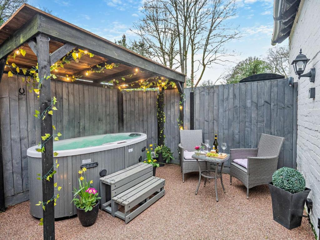 a backyard with a hot tub and a table and chairs at 1 Bed in Christchurch 54900 in Ringwood