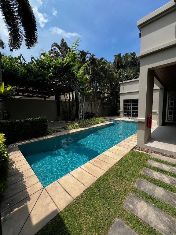 a swimming pool in front of a house at The Residence Resort in Phuket