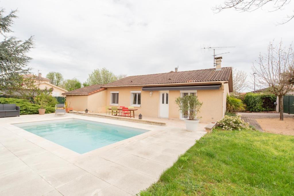 une maison avec une piscine dans une cour dans l'établissement Villa du Lac des Sablons, à Belleville-sur-Saône