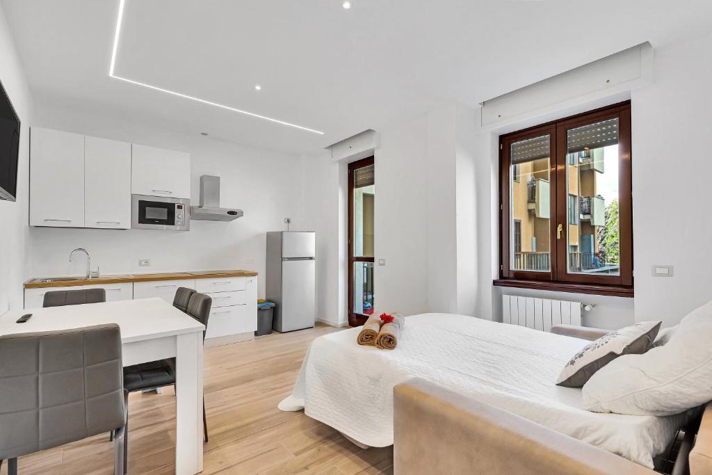 Camera bianca con letto e cucina di Alessia's Flat - Bonomelli 2 a Bergamo