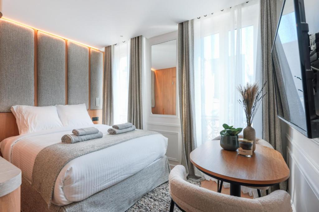 une chambre d'hôtel avec un lit, une table et une fenêtre dans l'établissement Petit Refuge Urbain - Paris 11, à Paris