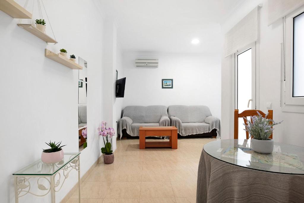 una sala de estar con un sofá y una mesa en Aptº Jábega, Familias y Parejas, en Conil de la Frontera