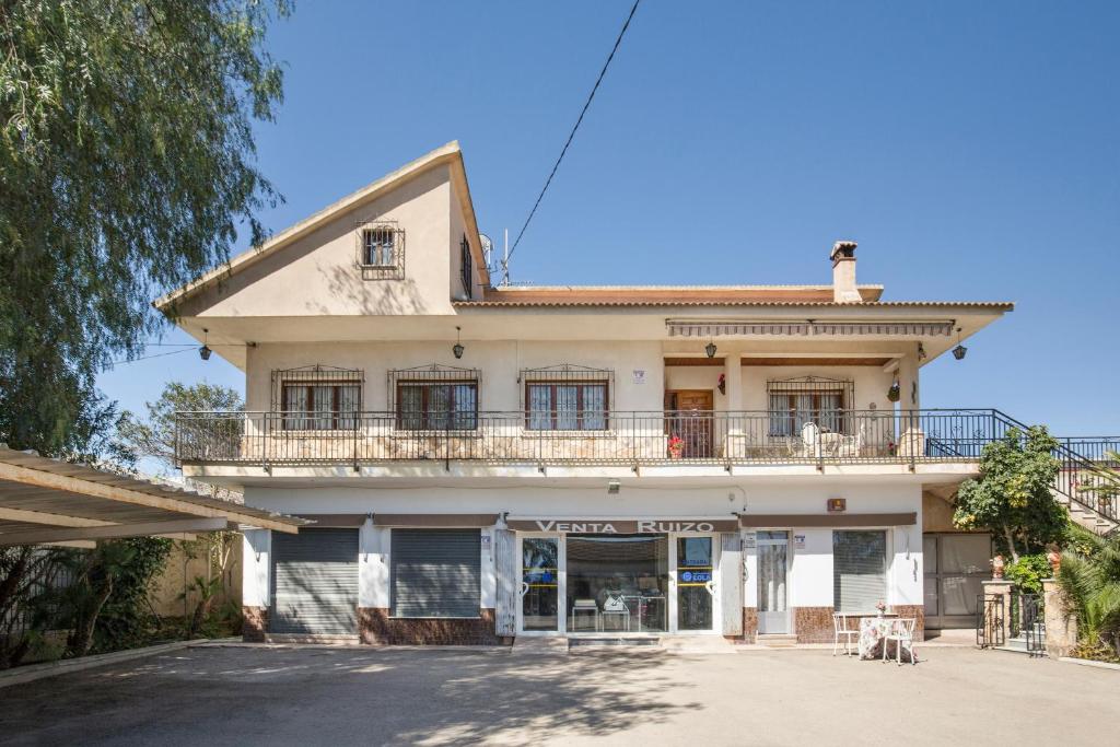 Una casa antigua con un balcón encima. en Casa Venta Ruizo, en Lorca