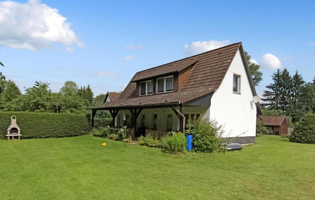 a white house with a brown roof on a green field at Cozy Apartment In Blankensee With Kitchen in Blankensee