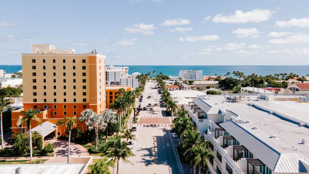 een luchtzicht op een stad met gebouwen en de oceaan bij The Atlantic Suites on the Ave in Delray Beach