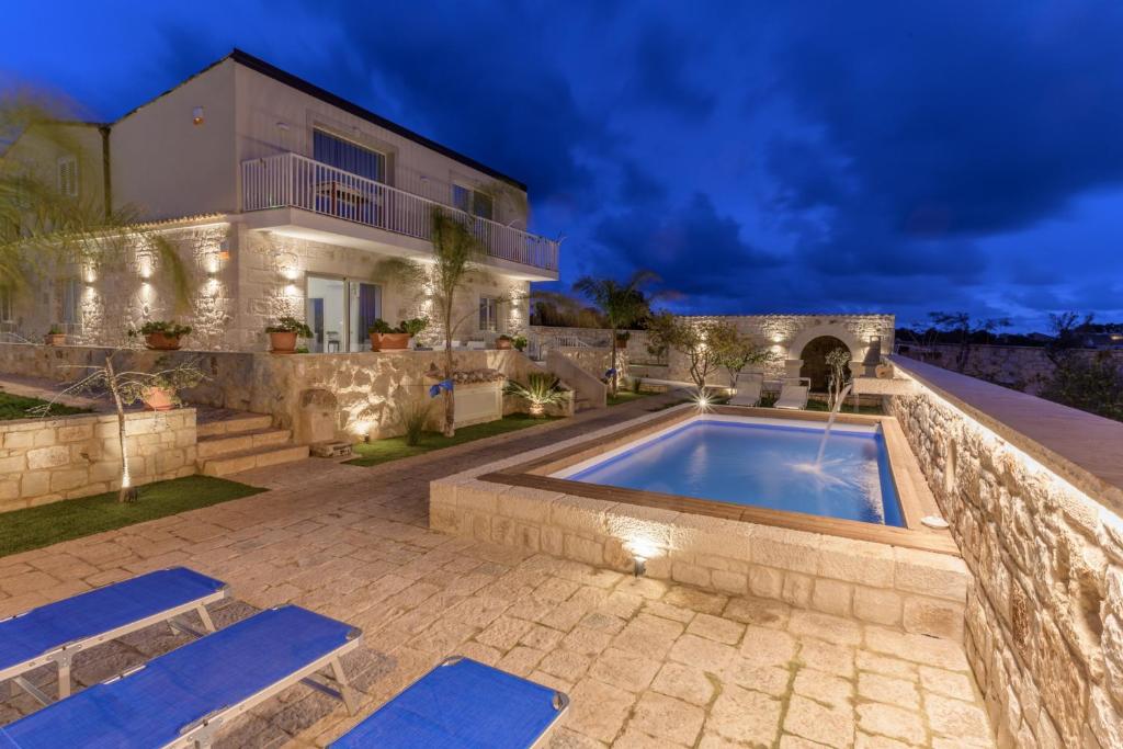 Villa con piscina frente a una casa en Villa Arjana, en Camemi