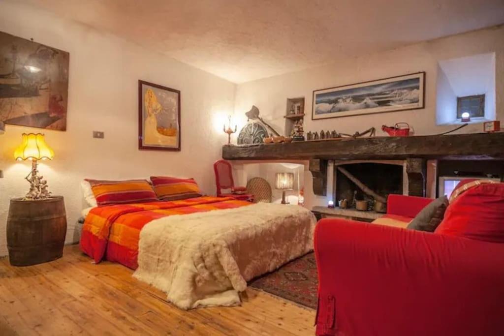 una camera con letto e camino di Modest & Cheap Tavern for a Spartan Retreat a Courmayeur