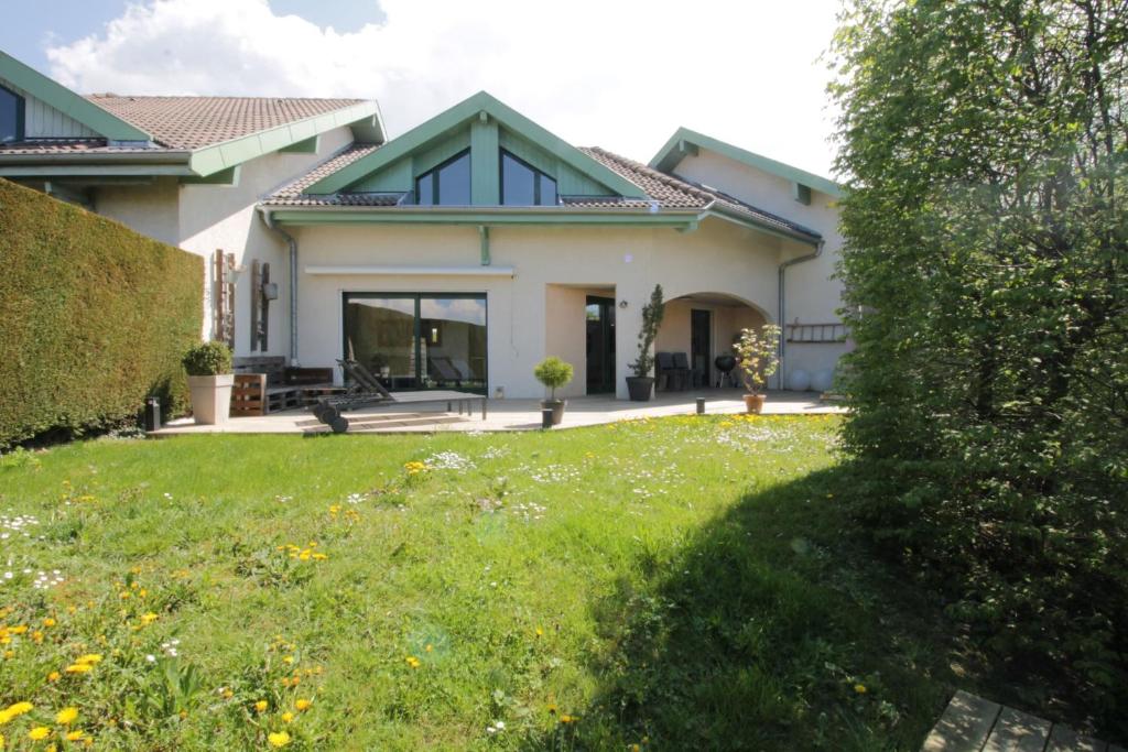 uma casa com um jardim verde em frente em Pretty terraced house with garden level and garage em Aix-les-Bains