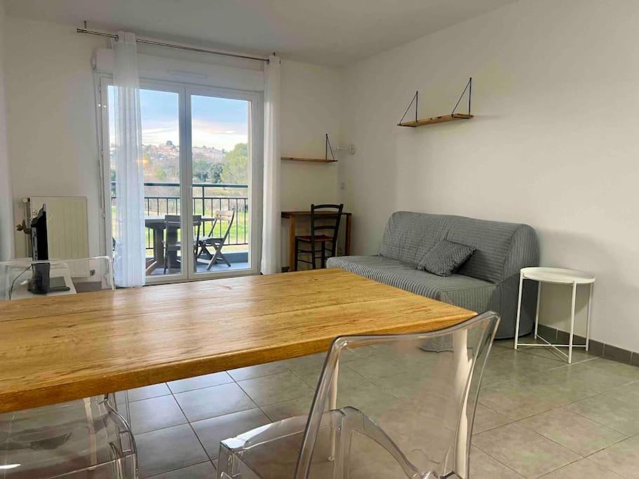 un salon avec une table et un canapé dans l'établissement Le Mérida, à Juvignac