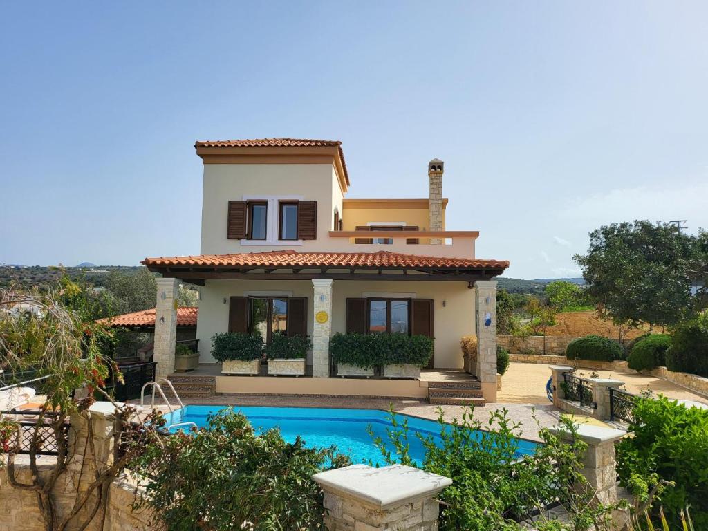 una casa con piscina frente a ella en Agnanti Despoina villa with private pool, en Skouloúfia