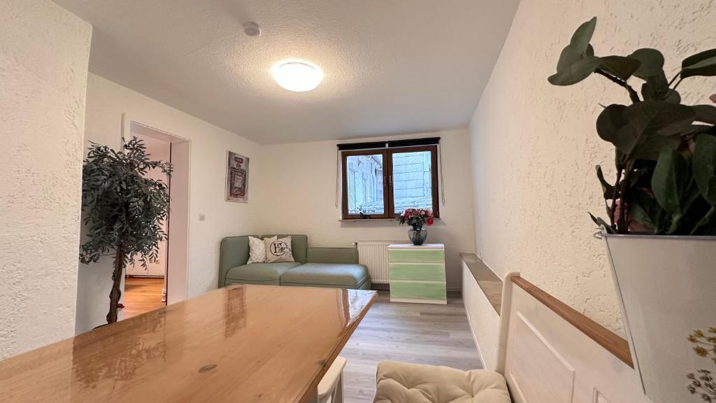 een woonkamer met een tafel en een bank bij Apartment am Waldbach in Gernsbach