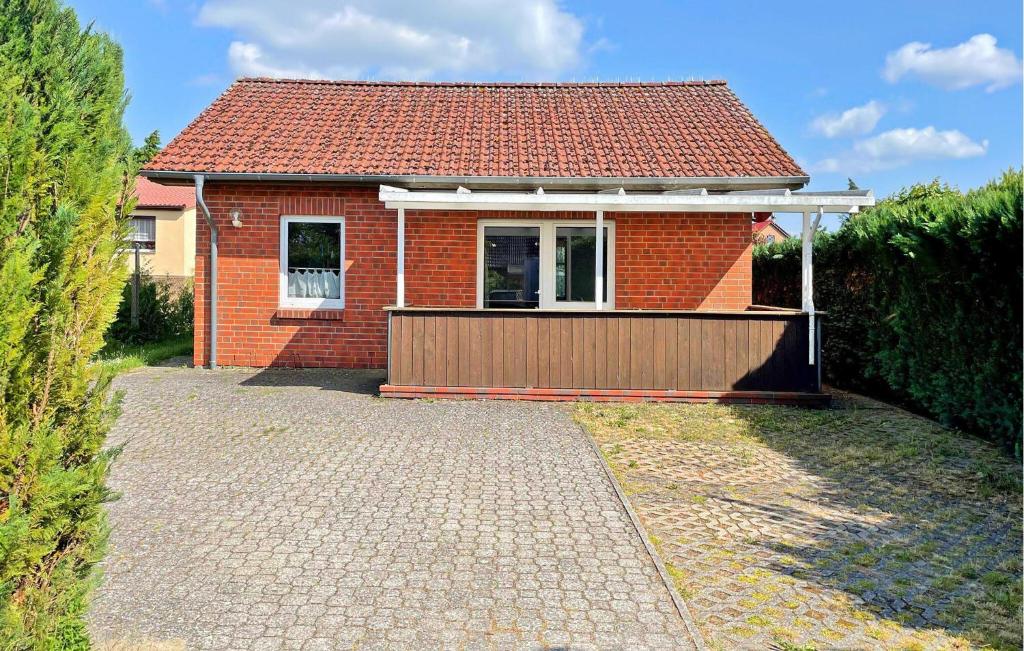 a small red brick house with a garage at Lovely Home In Klink With Kitchen in Klink