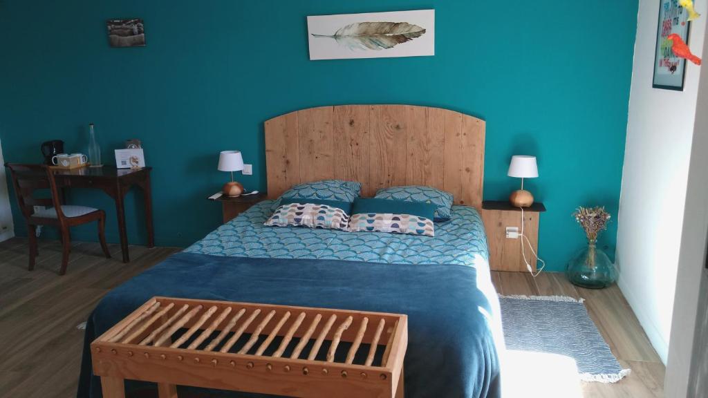 a blue bedroom with a large bed with blue sheets and pillows at Rêve de Causse in Saint-Michel