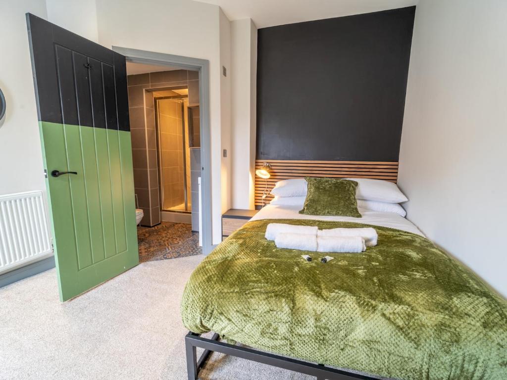 a bedroom with a bed with a green bedspread at Modern work Retreat with Dedicated Workspace Pass the Keys in Beeston