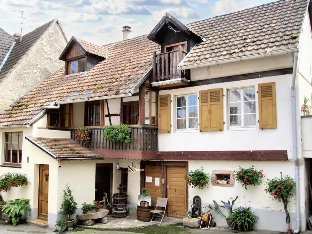 uma grande casa branca com uma varanda em Maison de 3 chambres avec terrasse amenagee et wifi a Ingersheim em Ingersheim
