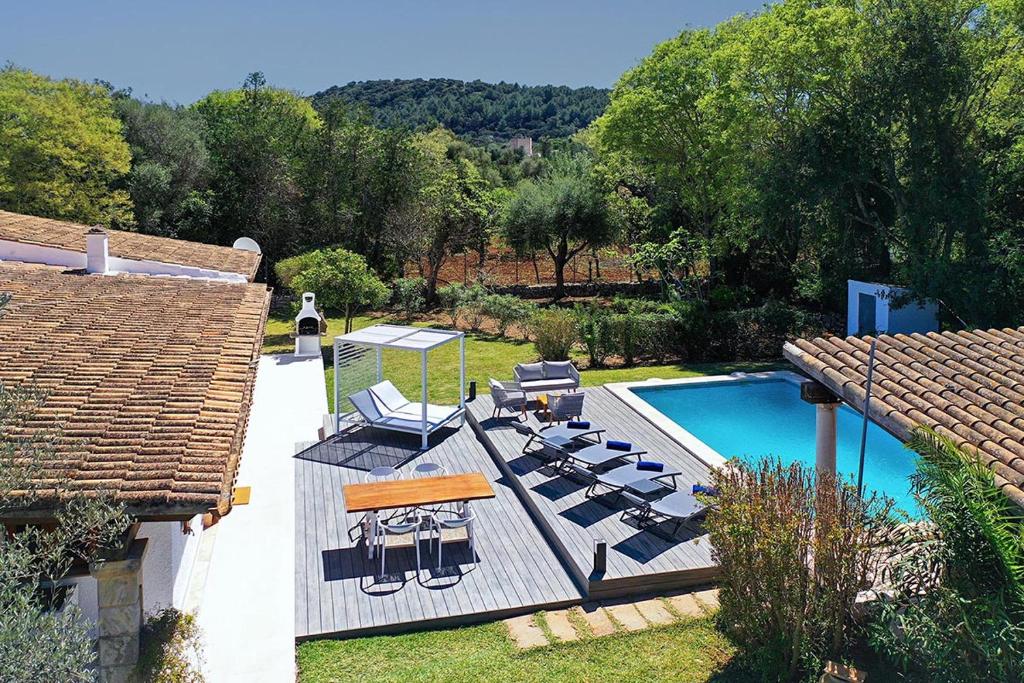 a backyard with a pool and chairs and a house at Villa Alegre in Pollença