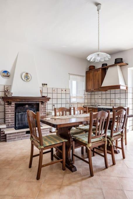una sala da pranzo con tavolo e sedie in legno di Country Chic Antico Casale - piscina idromassaggio lettini, solarium, cinema experience, wifi, parcheggio a Caiazzo
