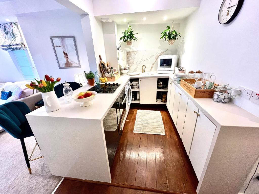 uma cozinha com armários brancos e uma bancada em The Terrace Garden Flat em Bournemouth