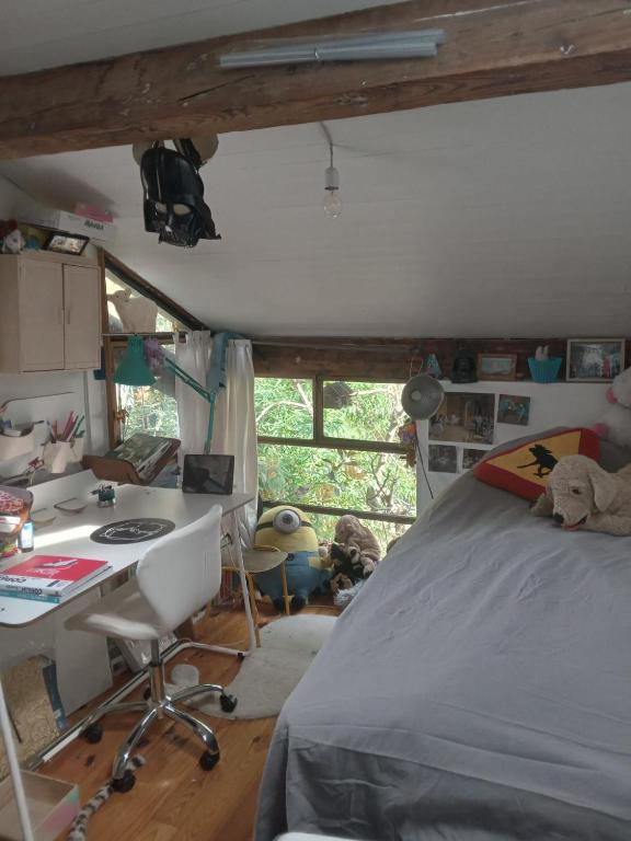 sypialnia z łóżkiem i biurkiem w obiekcie Paris, central et calme w Paryżu
