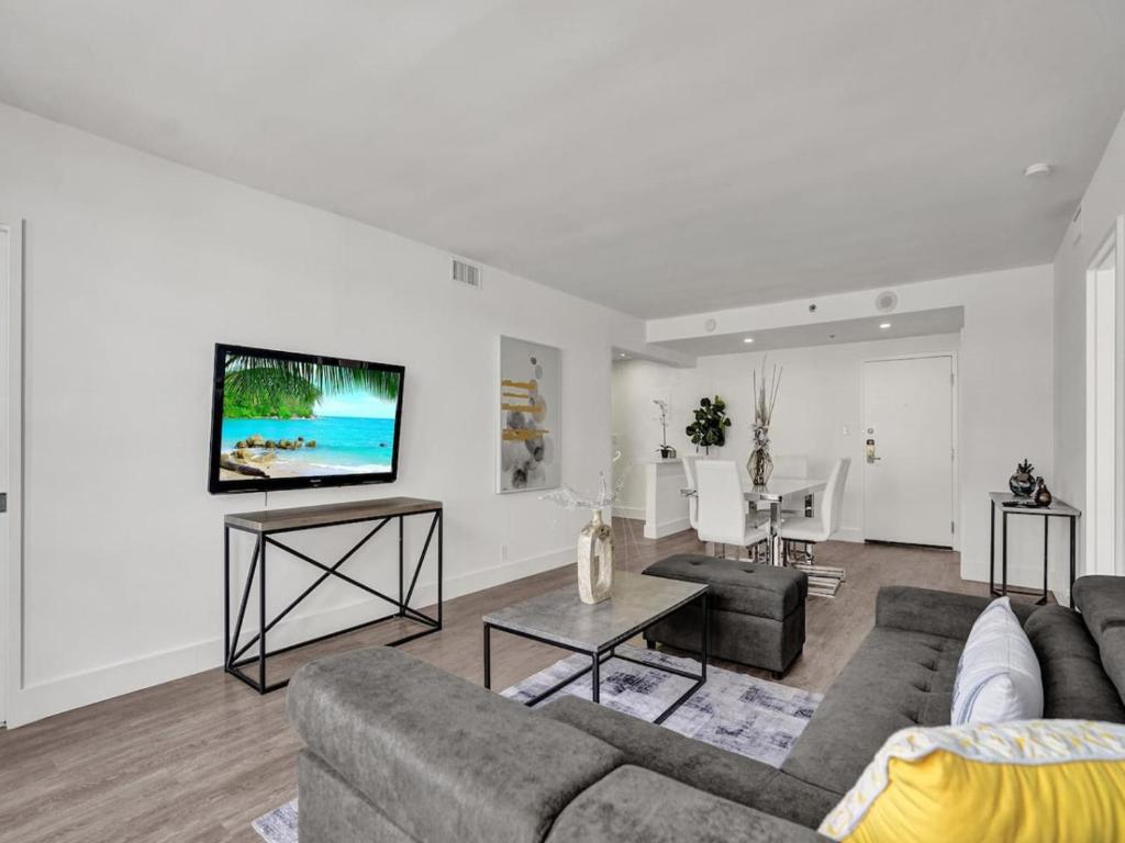 a living room with a couch and a tv on a wall at Gorgeous Miami Beach Condo 1614 in Miami Beach