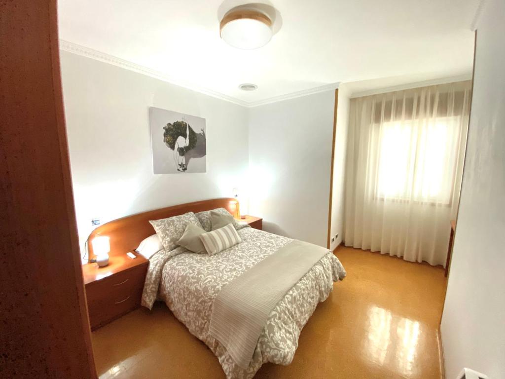 1 dormitorio con cama y ventana en Apartamento Rivela, en Burela de Cabo