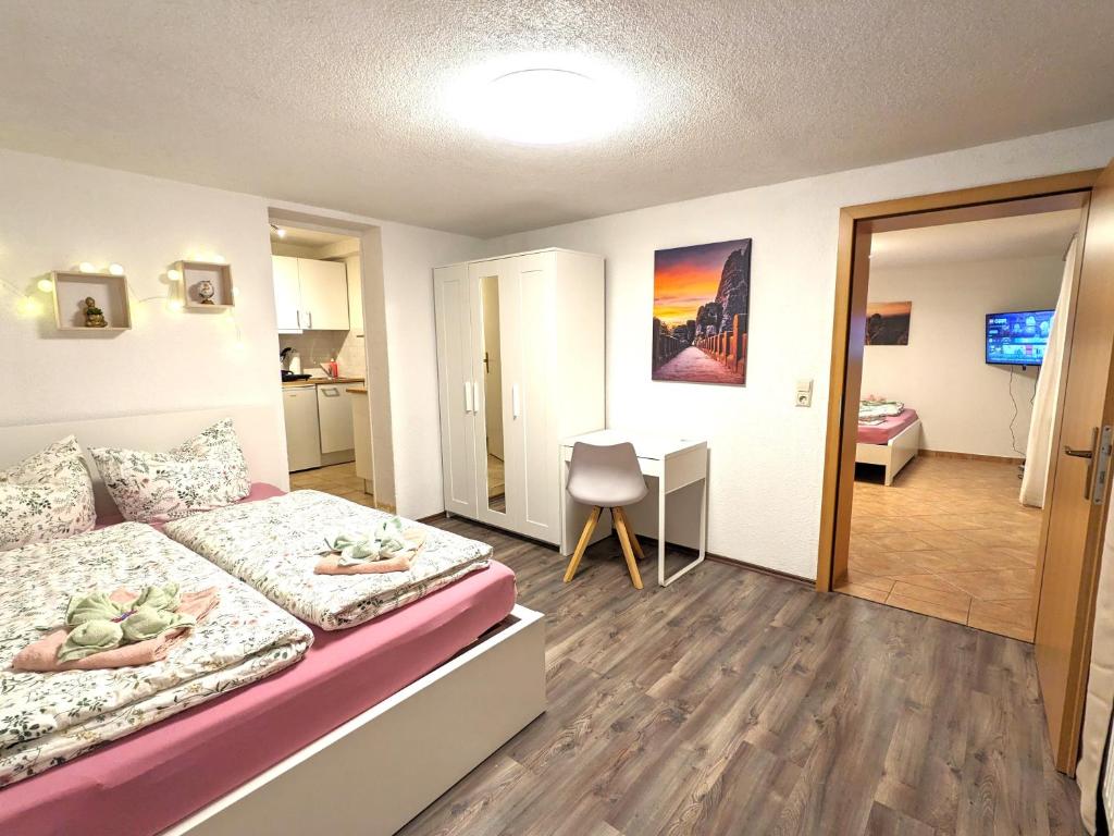 a bedroom with a bed and a desk in it at B3 - Urlaubsmagie Kleine Wohnung für 4P direkt am Wanderweg mit eigener Terrasse in Sebnitz