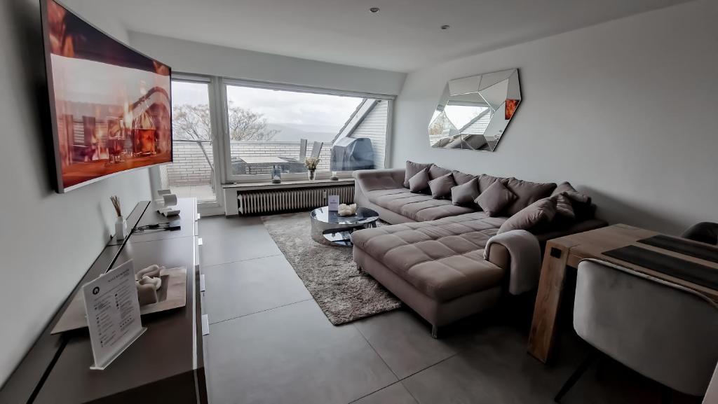 a living room with a couch and a large window at Moderne Wohnung mit Stadtblick in Herdecke