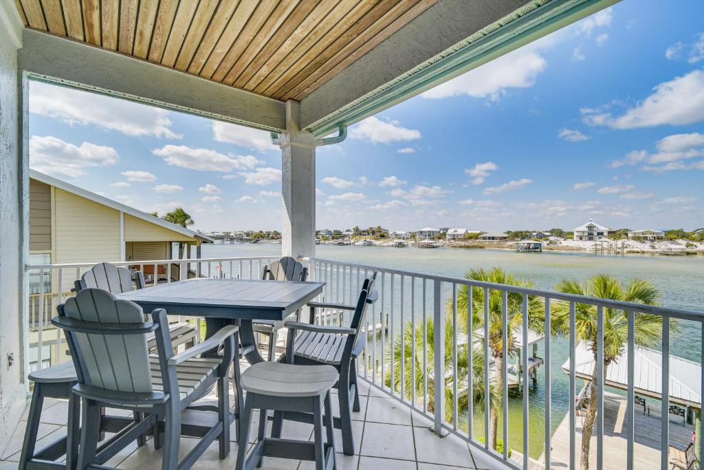 a balcony with a table and chairs and a view of the water at Dolphin Harbor Orange Beach Condo w/ Beach Access! in Orange Beach