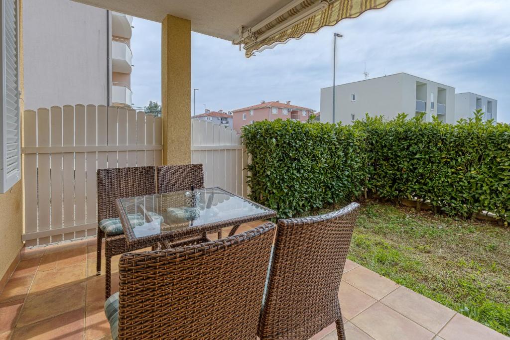 a patio with a glass table and two chairs at Apartment Mirjana in Karigador in Karigador