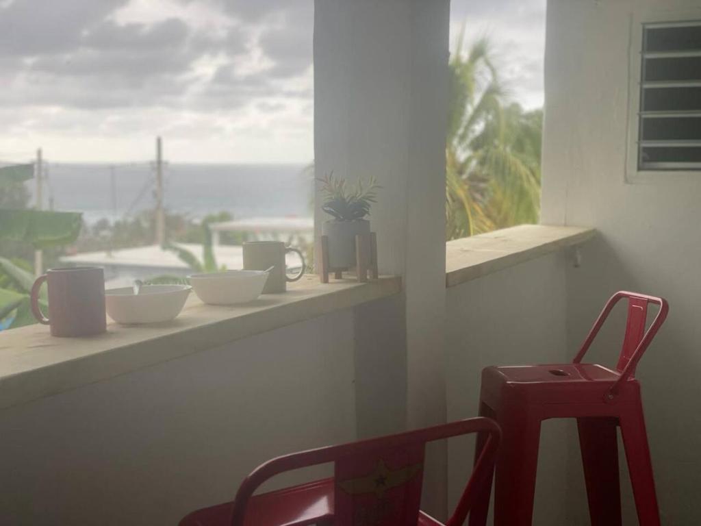 una ventana con cuencos y una silla en una cornisa en Ache Pa Ti I Isabela, en Isabela