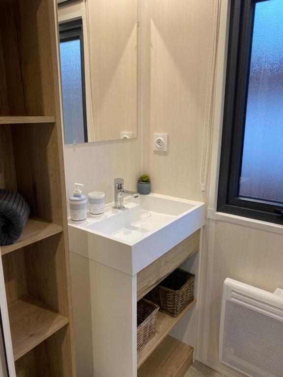 łazienka z białą umywalką i lustrem w obiekcie Camping pays de Beille w mieście Les Cabannes