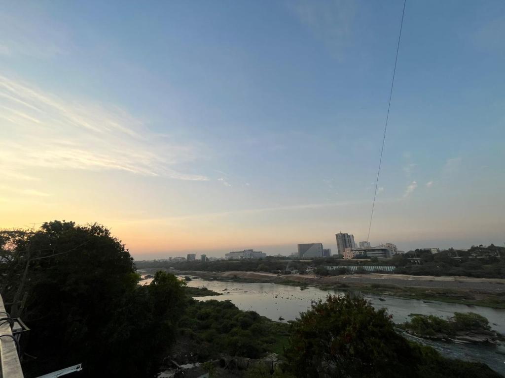 une vue sur une rivière avec une ville en arrière-plan dans l'établissement Jacuzzi house with private terrace ambiance, à Pune