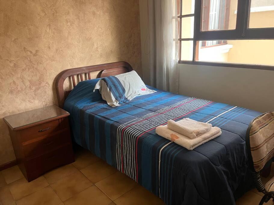 1 dormitorio con 1 cama con 2 toallas en Casa grande perfectamente ubicada, en Cochabamba