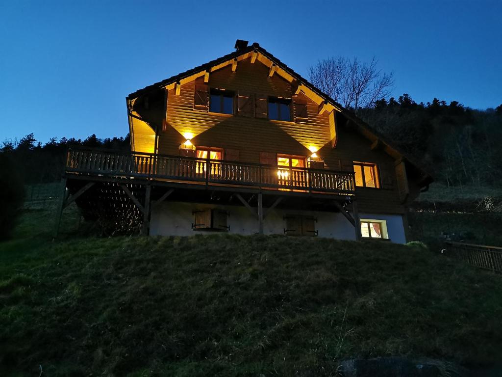 uma casa no topo de uma colina à noite em The dream catcher -Spa- panoramic sauna- 2 MINUTES FROM THE SLOPES em La Bresse