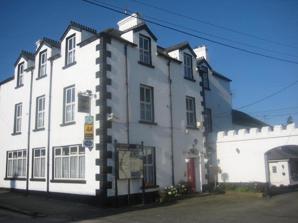 a white building with a red door at Tynte House in Dún Luáin