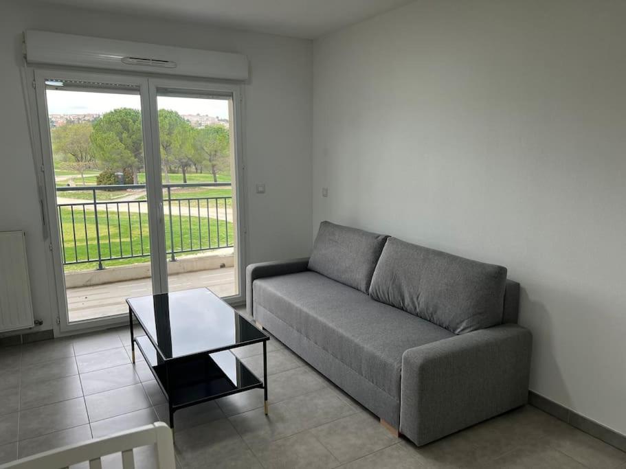 un salon avec un canapé et une table basse dans l'établissement Boston, à Juvignac